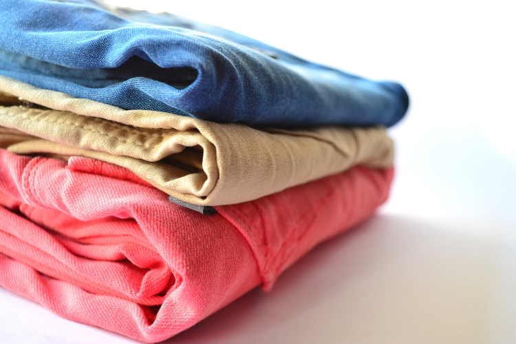 Pile of folded clothes. What To Pack For A Caravan Holiday