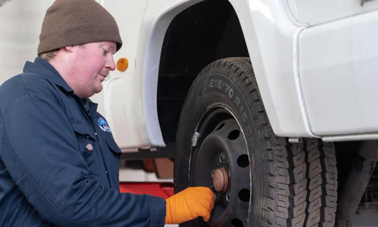 A member of the service team checking tires on a motorhome.