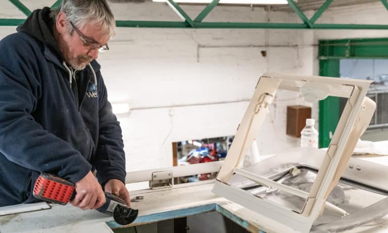 A member of the Webbs Motor Caravans' service team trimming the sunroof during a habitation test.