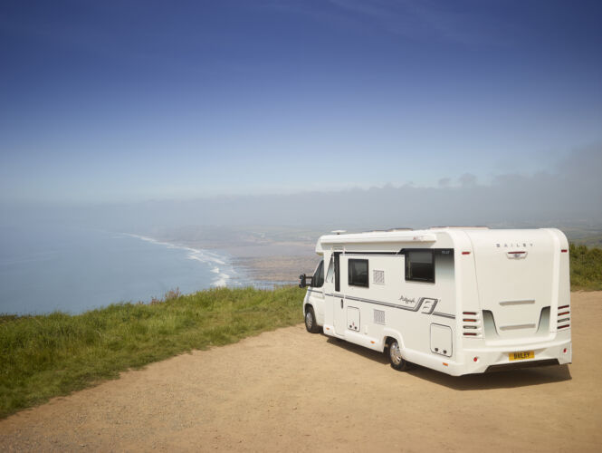 A motorhome parked on a cliff looking out towards the sea. For used and new motorhomes sales, explore our range online today. What To Consider When Selling Your Motorhome by Webbs.