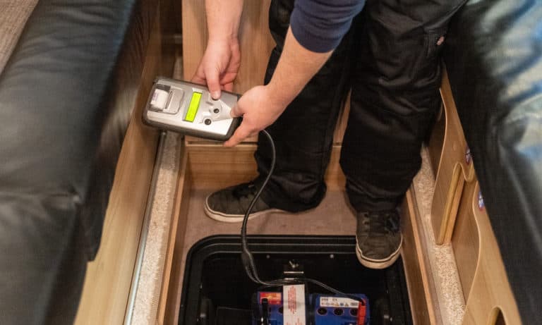 A service team testing the electrics inside of a motorhome.