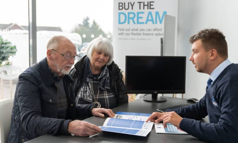 Sales staff discussing financial options with a couple at Webbs Motor Caravans. Get your motorhome on finance.