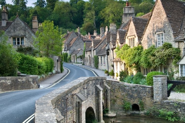 A road going over a bridge surround by houses and trees in a small village, one of Webbs most romantic UK destinations to go in your motorhome.
