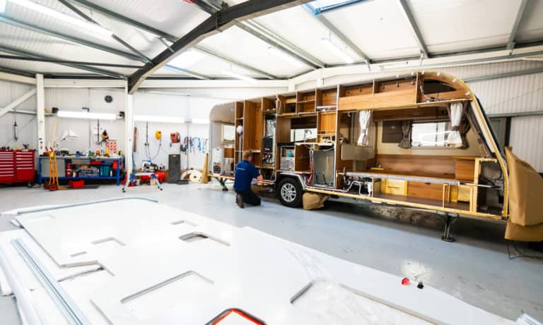 Side-view of a caravan's interior and the service team conducting a habitation inspection in the Webbs Caravans' service centre.