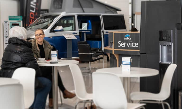 Customers waiting at Webbs Motor Caravans' Service centre in front of a Redline Campervan.