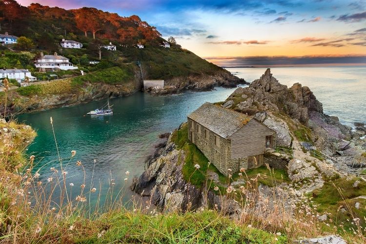 A sunset in a cove by the sea in Cornwall. The Most Romantic UK Destinations To Go In Your Motorhome by Webbs