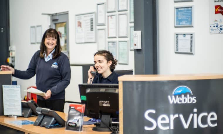 Staff members working behind the Webbs Motor Caravans' service desk.