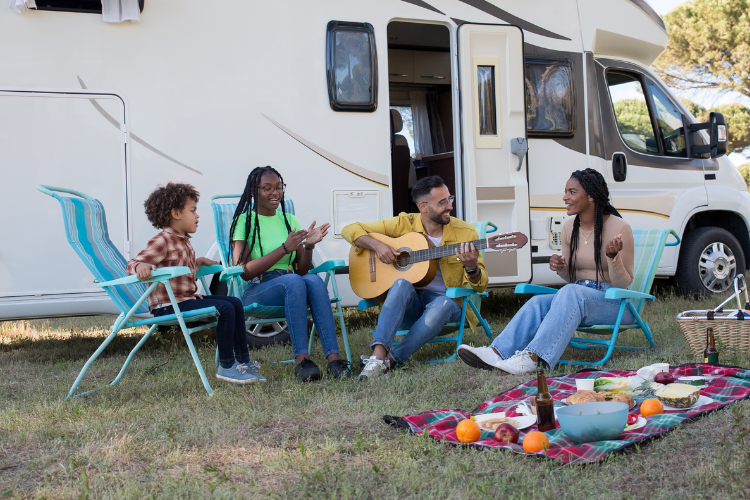 A family enjoying their campsite picnic. Why a Touring Holiday is a Great Value for Money Option in 2023 by Webbs.