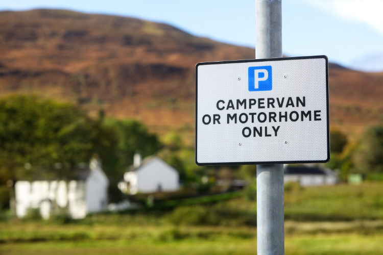 A sign for campervans and motorhome parking. Touring Routes to Explore in the UK by Webbs.