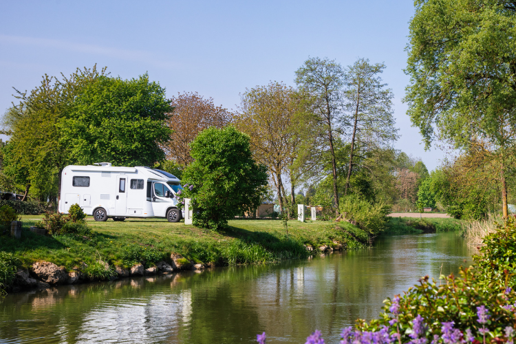 A motorhome parked next to a river in the Peak District. Touring Routes to Explore in the UK by Webbs.