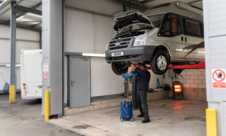 Inspecting an undercarriage at the Webbs Motor Caravans' service centre.