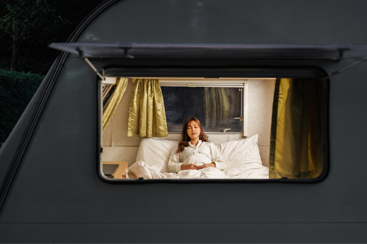 A caravan window open at night showing into the caravan. Summer survival tips in your caravan or motorhome by Webbs.