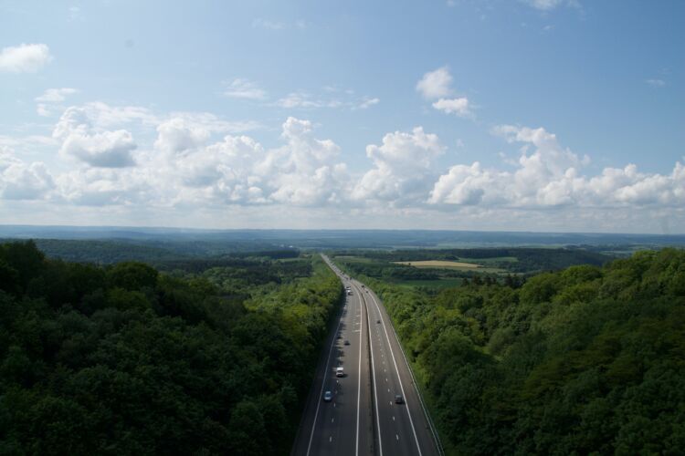 A long stretch of road with woodland and fields either side. How To Plan Your Perfect Motorhome Getaway by Webbs.